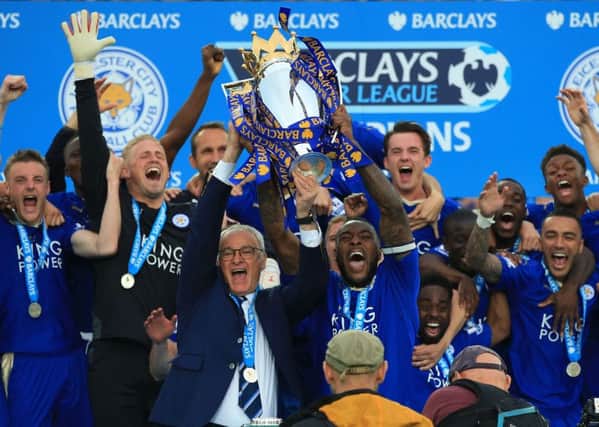 Leicester City captain Wes Morgan and manager Claudio Ranieri lift the trophy as the team celebrate winning the Barclays Premier League last season.