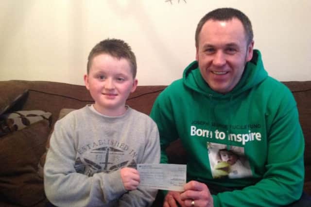 Darren Fucile hands a cheque to Hartlepool youngster, James Fewster-Smith, to help buy a specialised bed.
