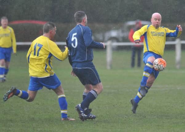 Over-40s League action: Grindon Broadway (yellow) take on Easington CIU in the gloom of last weekend.