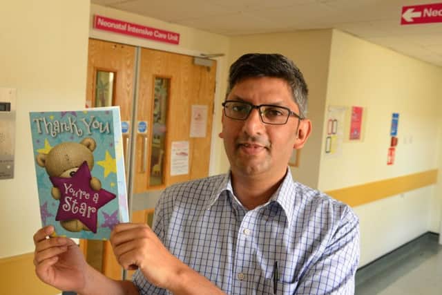 Dr Imran Ahmed, consultant neo-natologist, with a thank you card.