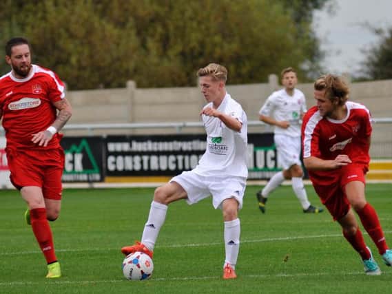 Coleshill, red, in action against Fylde in the FA Cup last season
