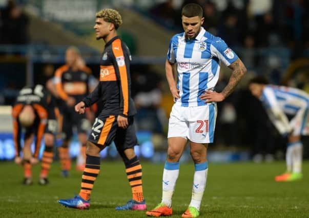 Huddersfield's Nahki Wells shows his despair at full-time as DeAndre Yedlin enjoys the moment of victory for Newcastle. Picture Bruce Rollinson