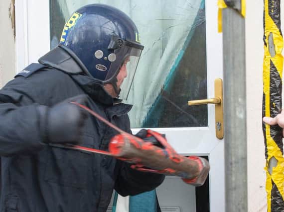Police use a battering ram to raid the home of one suspected dealer. Pic: Northumbria Police.