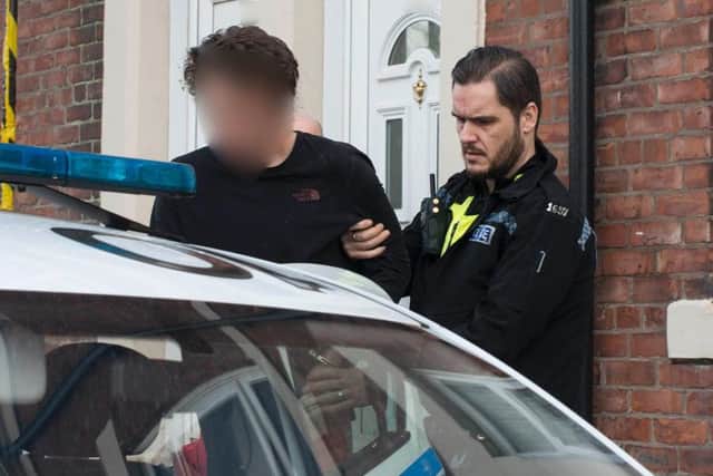 A suspect is taken away by police during the early morning raids. Pic: Northumbria Police.