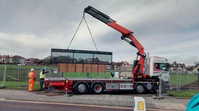 The new metal gates at Seaburn Recreation Park are lowered into place by workers.