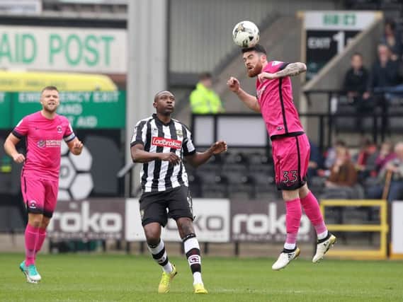 Liam Donnelly heads clear for Hartlepool United, watched by Notts County striker Shola Ameobi. Picture by Mark Fletcher | AH Pix )