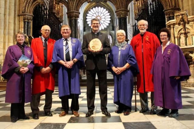 The Very Reverend Andrew Tremlett, Dean of Durham, with Durham Cathedral volunteers and the award.