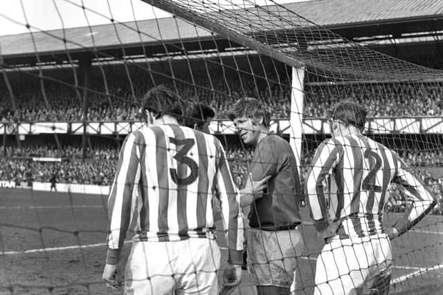 Jimmy Montgomery receives treatment for an arm injury in the Roker End goal