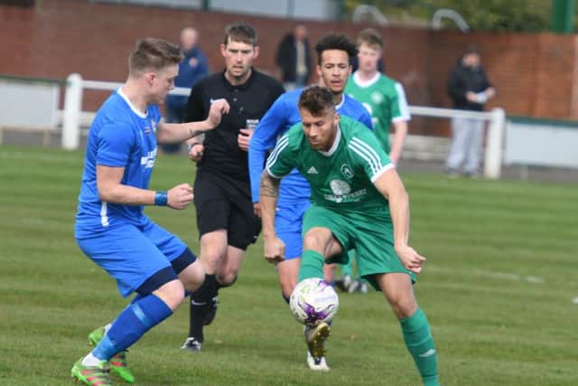 Easington Colliery striker David Paul (green) takes on the Brandon United defence