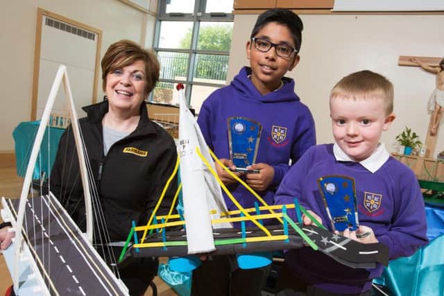 Brigid McGuigan, Community Engagement Manager for Farrans Construction, with winning pupils Joel Cijo and Ben Peggie.