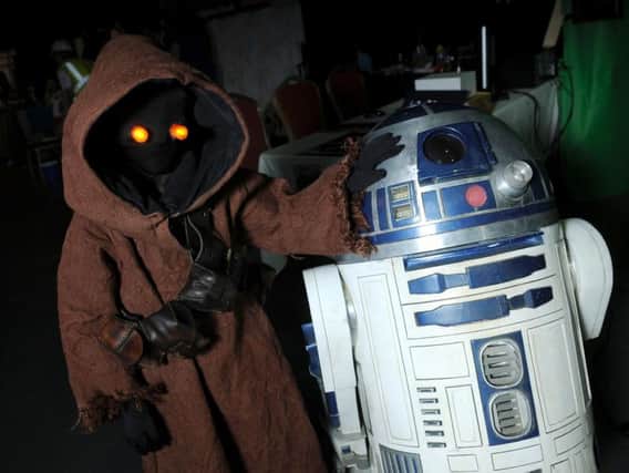 A Jawa, left, makes an appearance at a Star Wars convention.