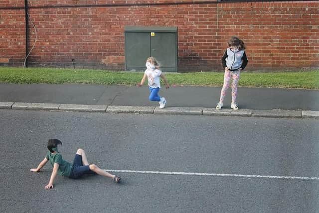Youngsters - whose faces have been blurred out by police - have been seen playing in the road.