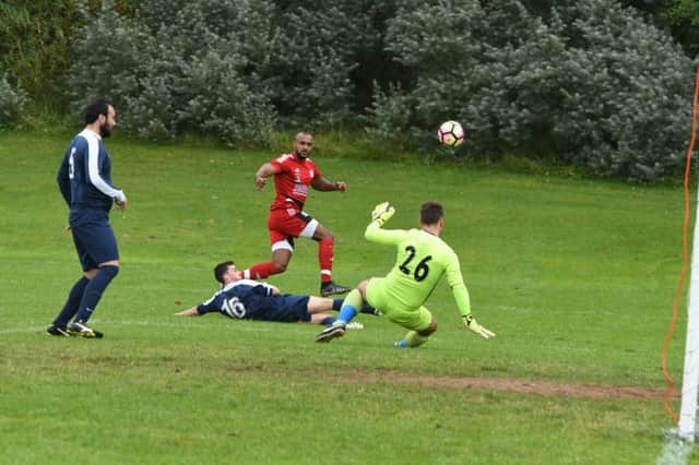 Southwick's Ash Davis (red) gets in a shot against Sunderland Sunday League rivals Railway Club last weekend.