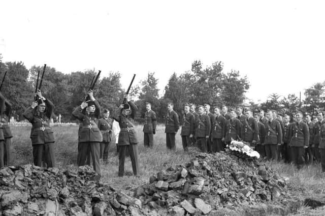 A salute is fired over the graves
