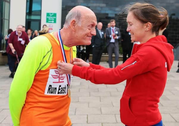 Albert Ellis, of Horden, is presented with his medal by Olympic marathon star Aly Dixon at East Durham College.