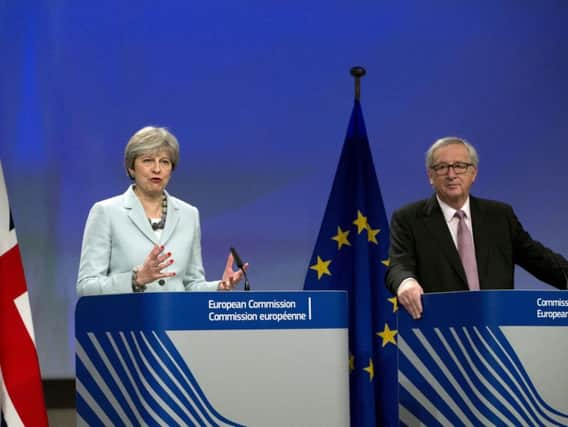 British Prime Minister Theresa May, left, and European Commission President Jean-Claude Juncker address a media conference at EU headquarters in Brussels on Friday, Dec. 8, 2017. British Prime Minister Theresa May, met with European Commission President Jean-Claude Juncker early Friday morning following crucial overnight talks on the issue of the Irish border (AP Photo/Virginia Mayo)