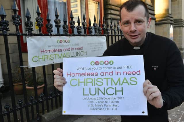 Father Marc Lyden-Smith outside St Mary's Church, Bridge Street, Sunderland with the Christmas Lunch poster. Picture by FRANK REID