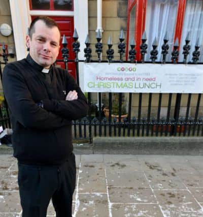 Father Marc Lyden-Smith outside of St Marys Church, Bridge Street, Sunderland with the Christmas Lunch poster. Picture by FRANK REID