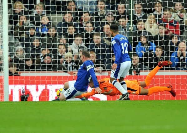 Wayne Rooney slides in to score for Everton after Karl Darlow spilled a header from Aaron Lennon.