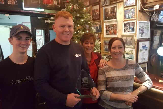 Manager at The Dolphin (holding award) Carl Donkin with the Echo's Pub of the Year honour alongside fellow staff.