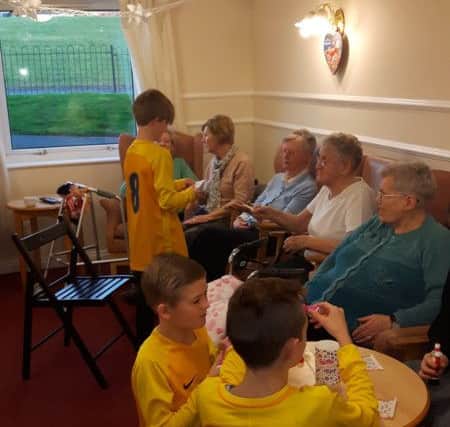 Velocity Phoenix under-11s team players playing games with residents at Hylton View Care Home.