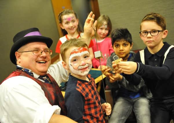 Youngsters are entertained at the Rainbow Trust's Christmas Party by magician Iain Jay.