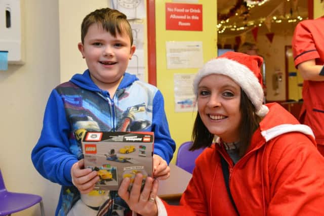 Fundraiser Emma Olsen donates Christmas presents to Sunderland Royal Hospital. Patient Gabriel Dance, 7.
