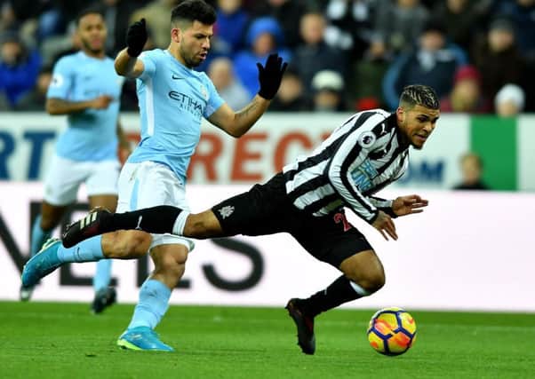 DeAndre Yedlin goes down under a challenge from Manchester City's Sergio Aguero.