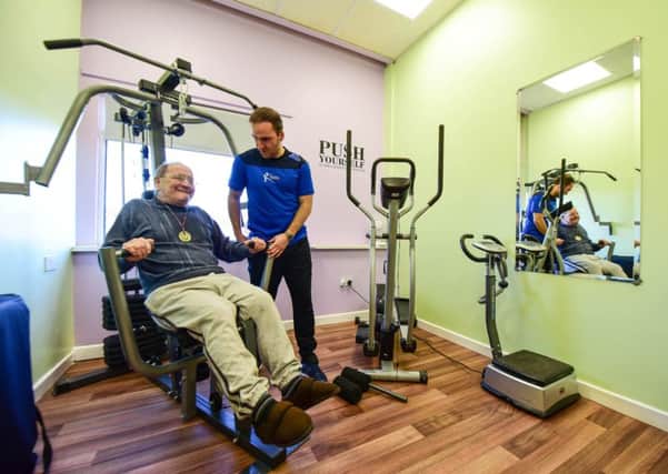 Sports Therapist Kevin Spanton helping one of the residents at the Yohden Care Complex to keep fit in their new gym.