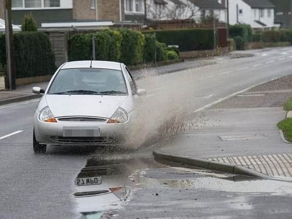 Car driving through a puddle. Picture issued by Confused.com