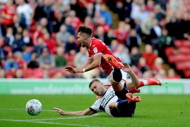 Tom Bradshaw is tackled by Middlesbrough defender Ben Gibson.