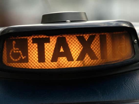 A taxi sign. Credit: PA.