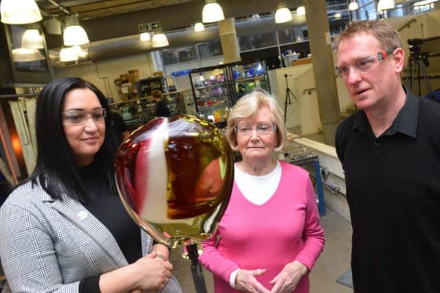 Gemma Lowery, along with Lady Elsie Robson and Colin Young, helps to make a glass award for Jermain Defoe which he will be given at this month's North East Football Writers Association Awards.