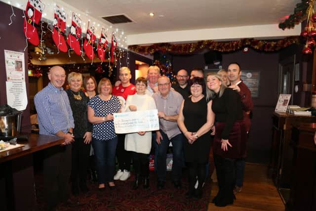 Supporters of St Benedicts Hospice gather together for a cheque presentation at The Colonel Prior pub for a quiz night in memory of the late Carole Moody.