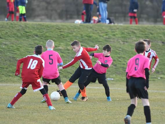 Under 11s derby action as Newcastle Boys Club Inter, in pink, take on Redby CA Whites, in red and white.