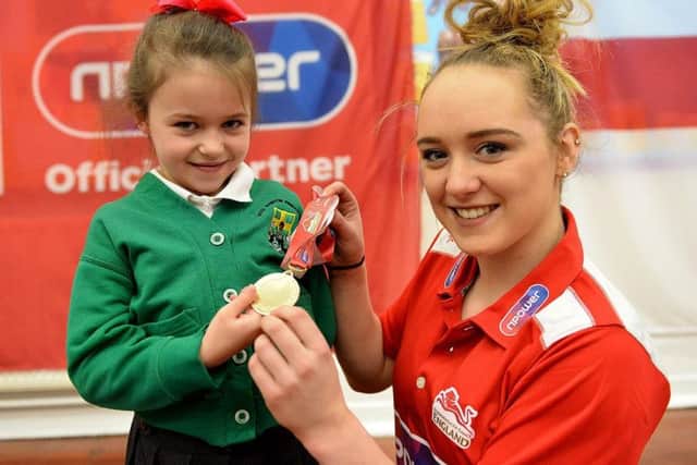 Amy Tinkler presents West Rainton Primary school gymnastic club member Tiffany Ward with her medal.