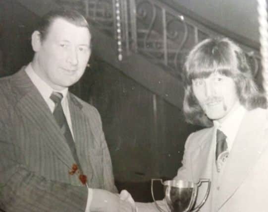 Vic Avery, right, collects the trophy as the winner of the Champion of Champions tournament in the 1980s.