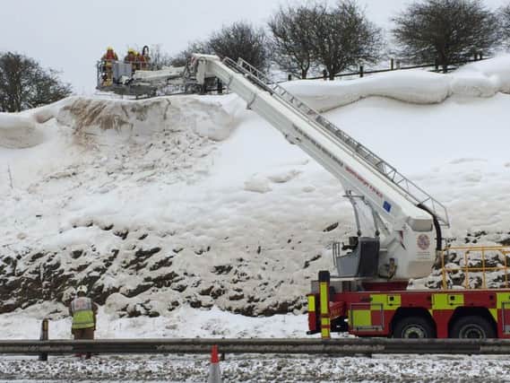 Firefighters tackle the snow mounds near Houghton Cut.