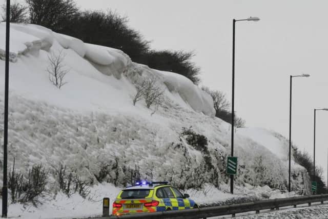 Police on the scene of the overhanging accumulation of snow on the A690 at Houghton Cut.