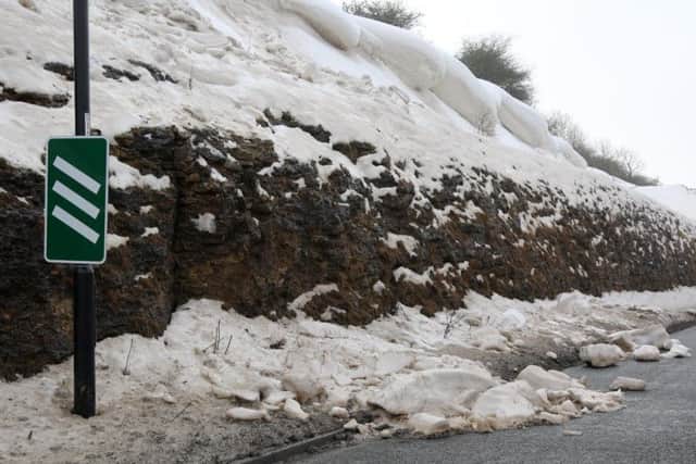 Some of the snow and ice which has fallen onto the road.