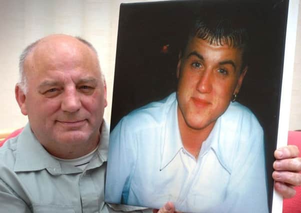 John Johnson with a photo of murdered son Kevin