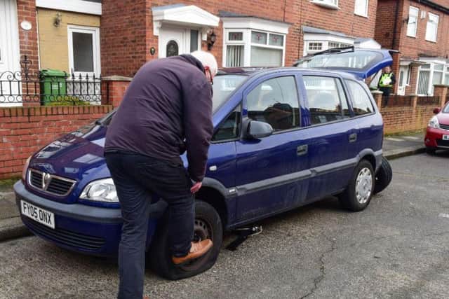 An Orchard Street resident starts to remove his damaged tyre.