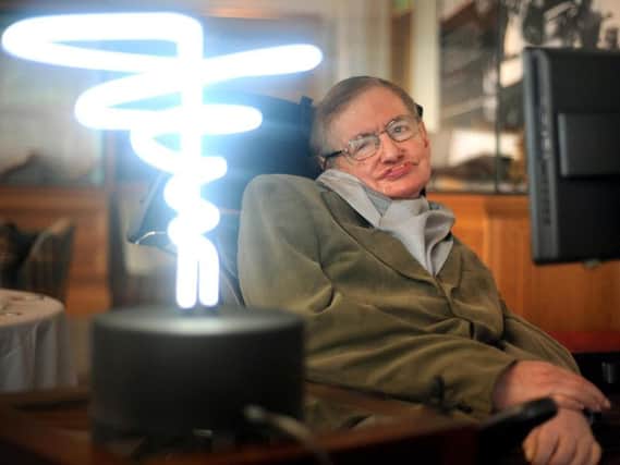 A photo taken in 2012 of Professor Stephen Hawking posing beside a lamp titled 'black hole light' by inventor Mark Champkins, presented to him during his visit to the Science Museum in London. Anthony Devlin/PA Wire.
