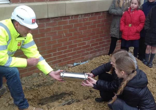 New Seaham Academy pupils bury a time capsule with help from Malcolm Hedley of Brims Construction.