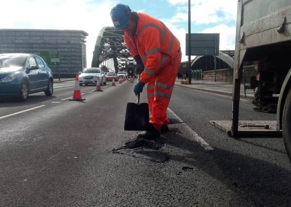 Worker filling potholes on Wearmouth Bridge in Sunderland.