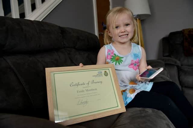 Emily Morrison holds her bravery award.