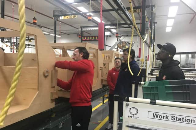 SAFC players Lee Camp, Lamine Kone and Lynden Gooch alongside manager Chris Coleman on a visit to Caterpillar in Peterlee.