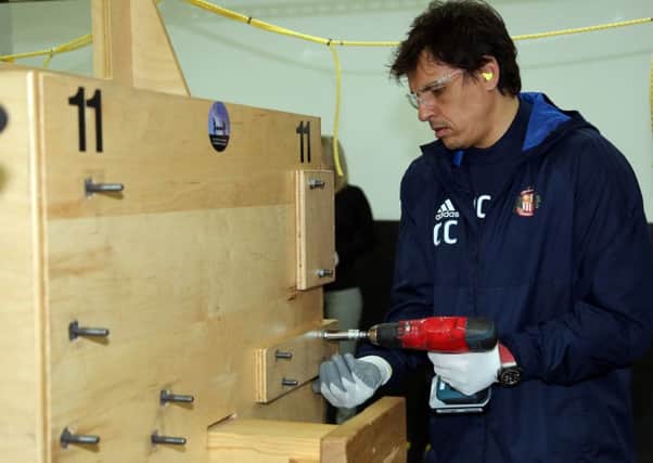 Chris Coleman shows his skills with a drill on the trip to the Caterpillar plant in Peterlee.