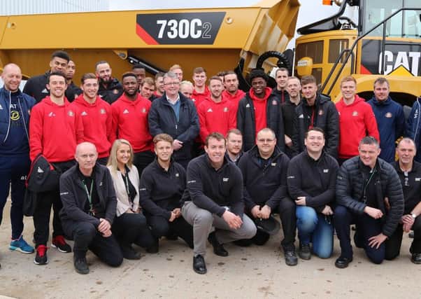 Sunderland players pose with Caterpillar staff on Tuesday.