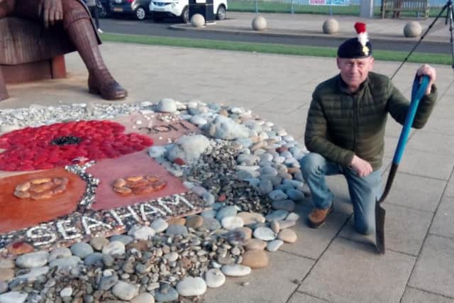 Dave McKenna in front of the pebble display created in front of the Tommy statue by the Seaham Remember Then Fund.